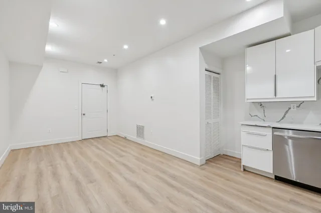 a view of a kitchen with wooden floor and electronic appliances