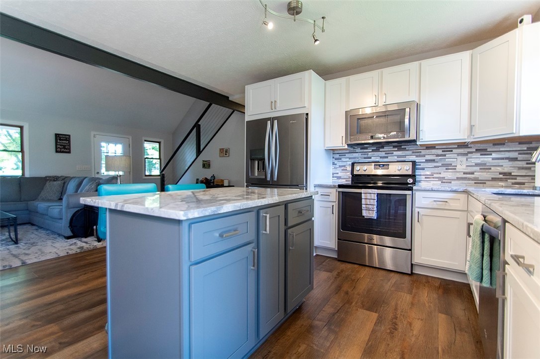 5859 Buffham Road Seville, OH 44273 - Photo 14 of 34 Kitchen with appliances with stainless steel finishes, plenty of natural light, light stone countertops, and white cabinetry