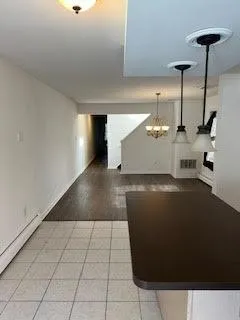 an empty room with wooden floor chandelier fan and windows