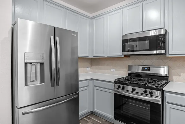 a kitchen with stainless steel appliances a refrigerator stove and microwave