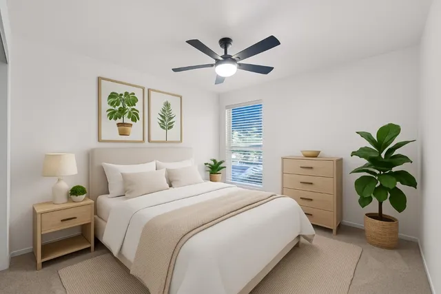 a bedroom with a bed and a potted plant