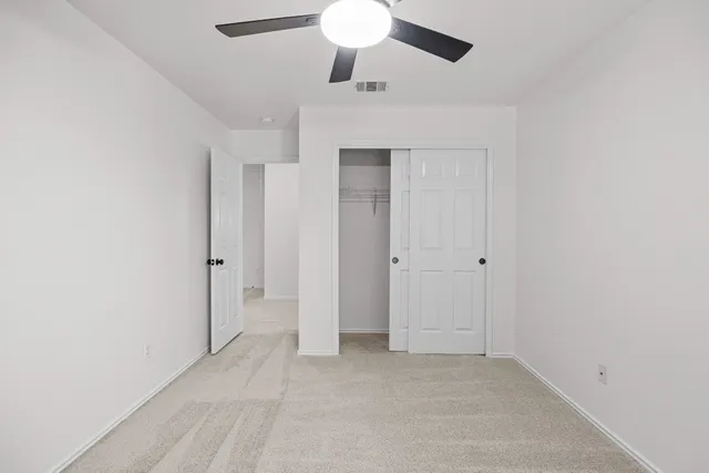 an empty room with a chandelier fan