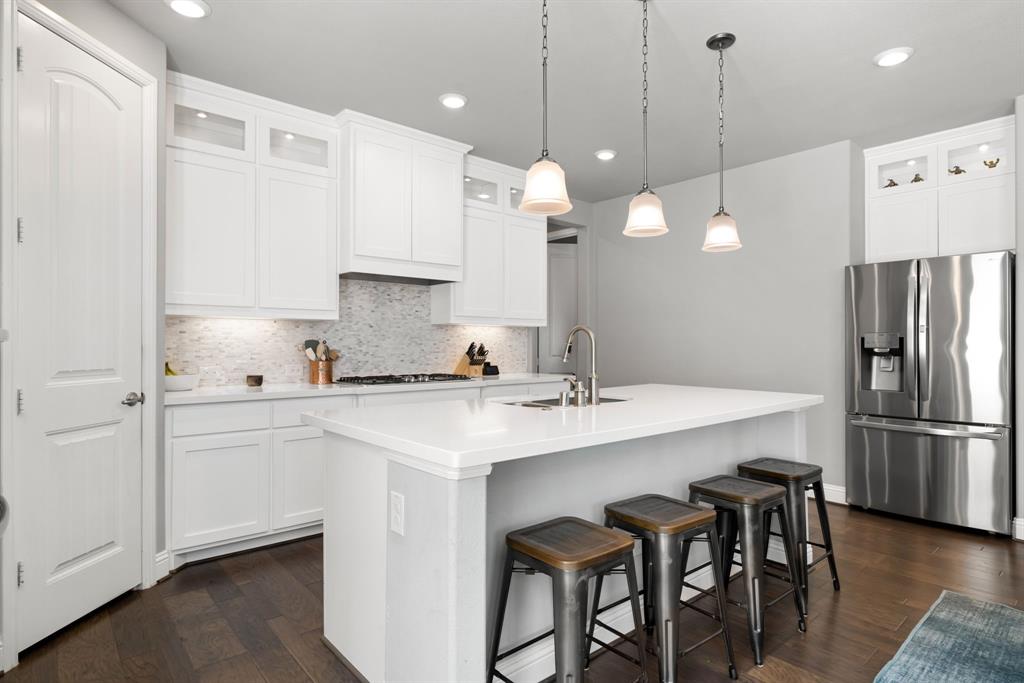 6309 Hall Road Frisco, TX 75034 - Photo 13 of 35 Kitchen featuring glass insert cabinets, stainless steel refrigerator with ice dispenser, tasteful backsplash, and recessed lighting