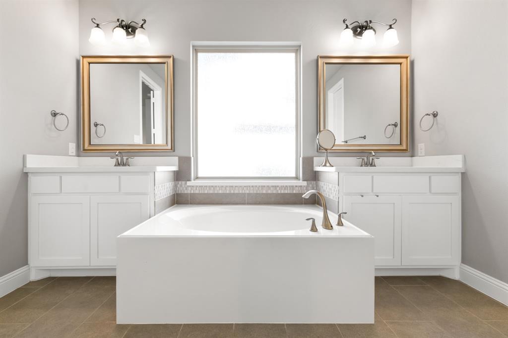 6309 Hall Road Frisco, TX 75034 - Photo 17 of 35 Full bathroom with two vanities, a bath, and dark tile patterned floors
