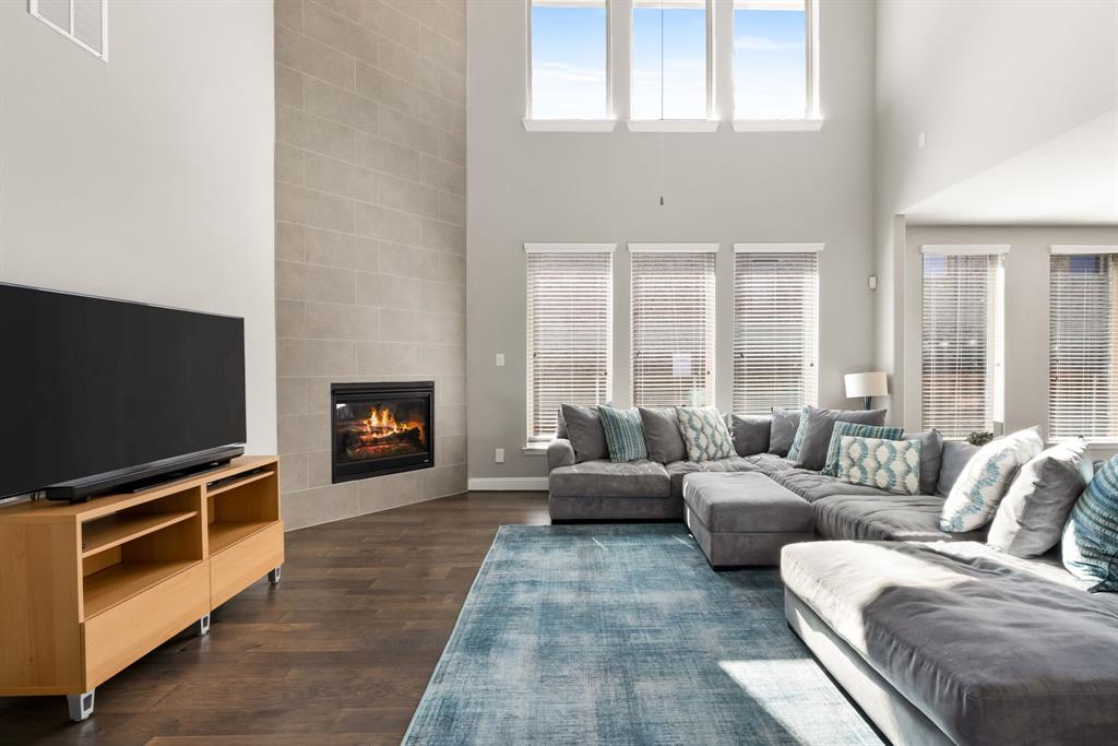 6309 Hall Road Frisco, TX 75034 - Photo 7 of 35 Living area with a tile fireplace, a towering ceiling, and dark wood finished floors