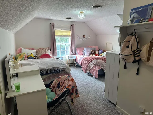 a bedroom with two beds and a window