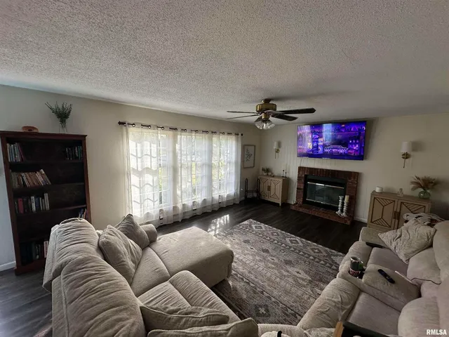 a living room with furniture a fireplace and a flat screen tv