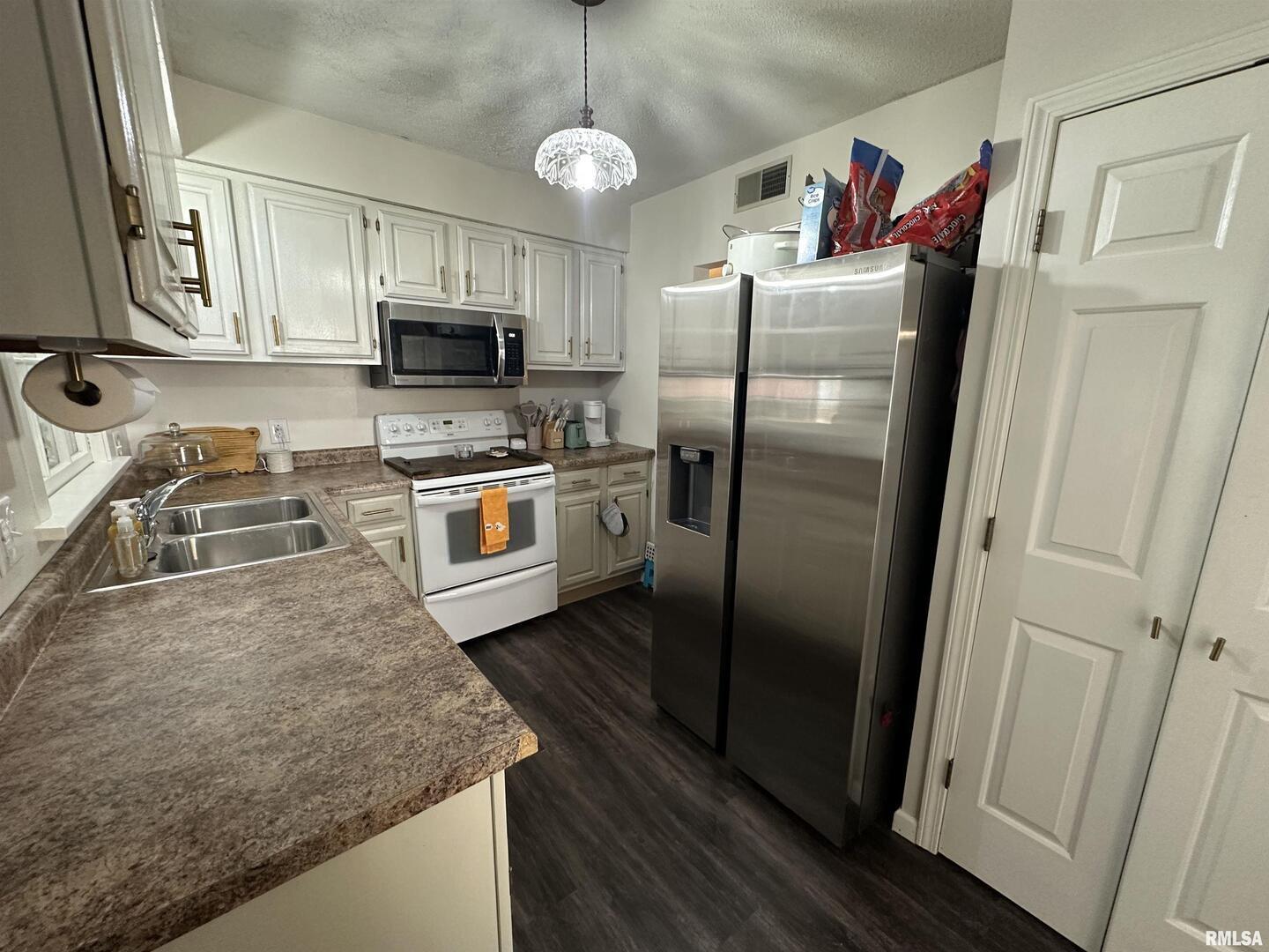 1307 Charles Street Carterville, IL 62918 - Photo 7 of 21 a kitchen with stainless steel appliances granite countertop a refrigerator a stove and a sink with wooden floor