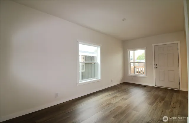 a view of a kitchen with wooden floor and electronic appliances