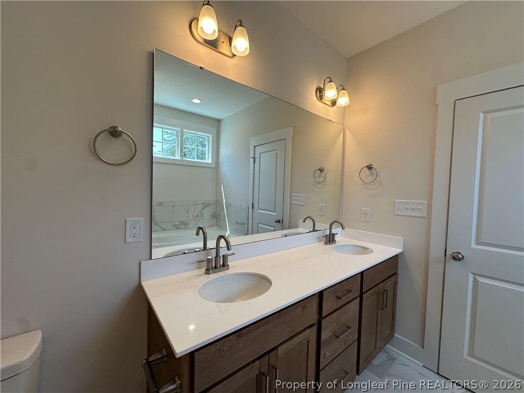 2908 Calloway Road Raeford, NC 28376 - Photo 16 of 25 a bathroom with a sink vanity and a mirror