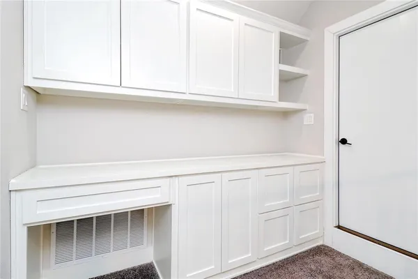a view of white cabinets and a window