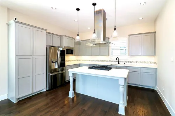 a kitchen with a sink a stove a refrigerator and a wooden floor