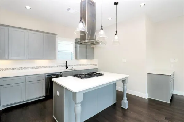 a kitchen with a sink a stove and wooden floor