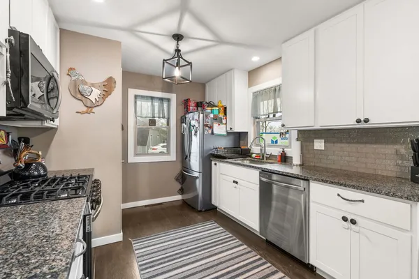 a kitchen with stainless steel appliances granite countertop a sink and cabinets