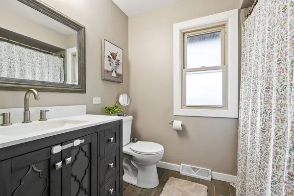 a bathroom with a toilet a sink and a window