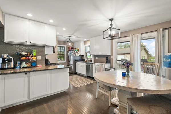 a kitchen with counter space dining table and wooden floor