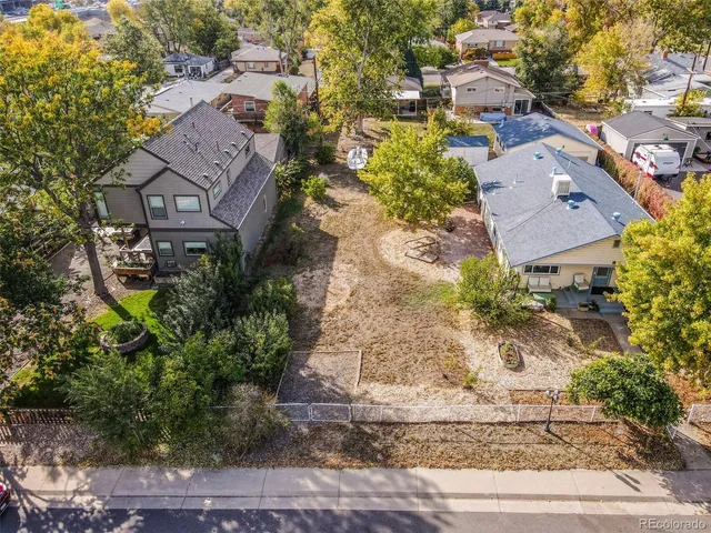 an aerial view of a house with a yard and a large tree