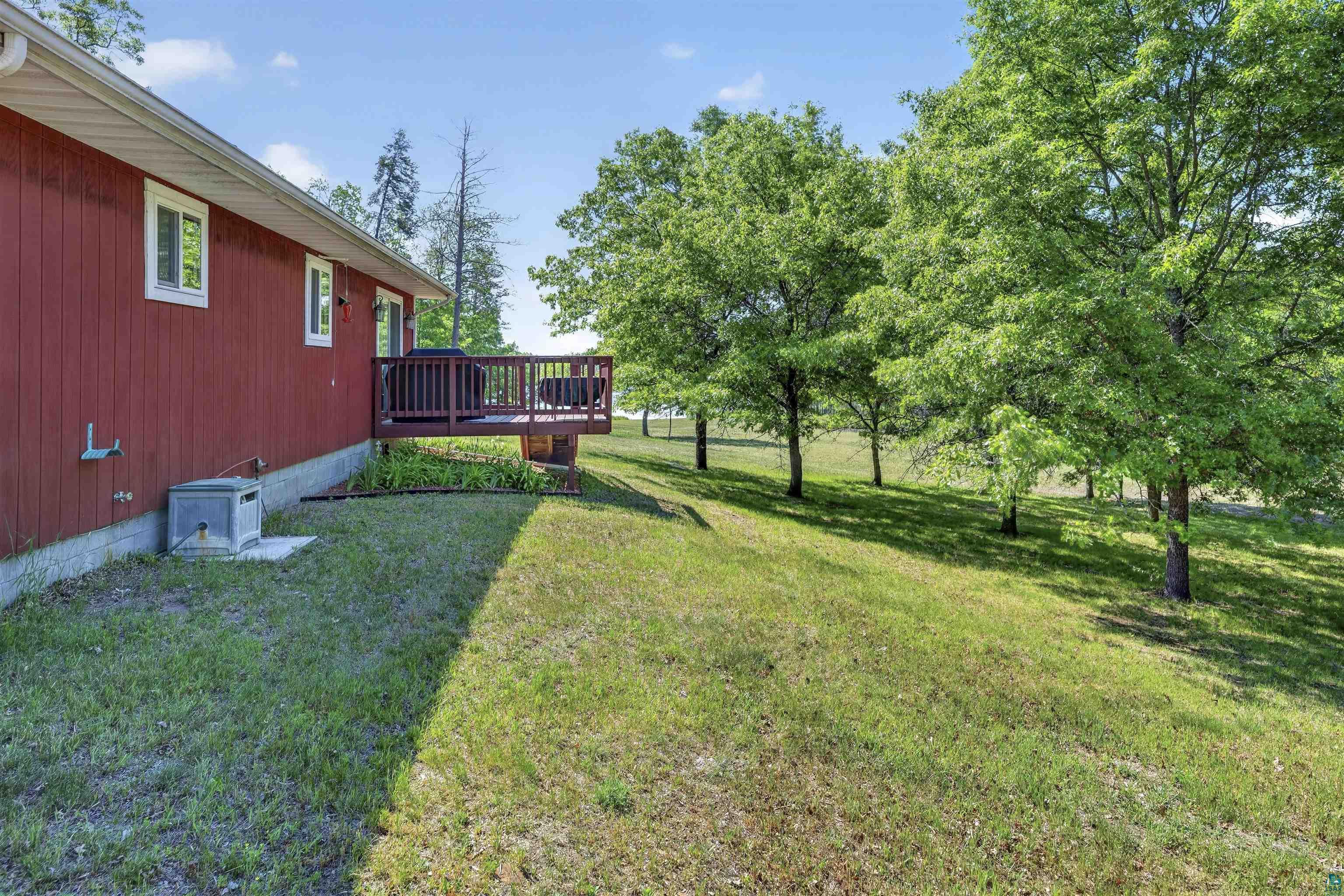 11702 East Mail Road Gordon, WI 54838 - Photo 28 of 60 Red siding exterior featuring multiple windows and an elevated wooden deck