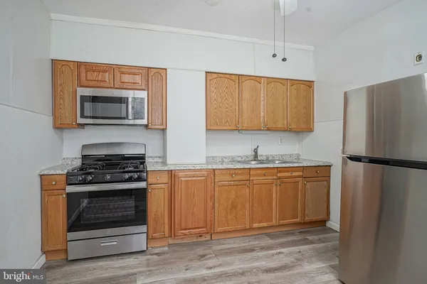 a kitchen with granite countertop stainless steel appliances and wooden cabinets