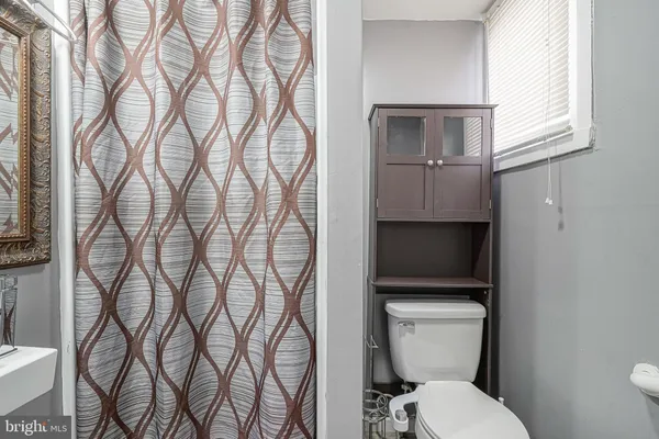 a white toilet sitting next to a bathroom sink and a window