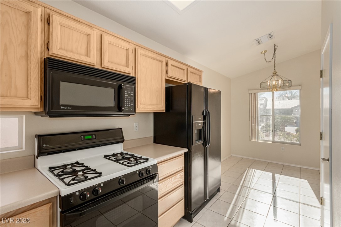 2148 Point Mallard Drive Henderson, NV 89012 - Photo 12 of 31 Kitchen featuring black appliances, light brown cabinets, light countertops, hanging light fixtures, and lofted ceiling