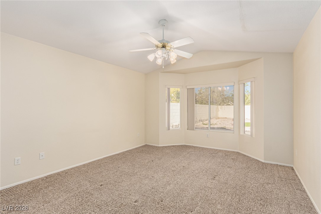 2148 Point Mallard Drive Henderson, NV 89012 - Photo 15 of 31 Spare room featuring carpet floors, vaulted ceiling, and ceiling fan