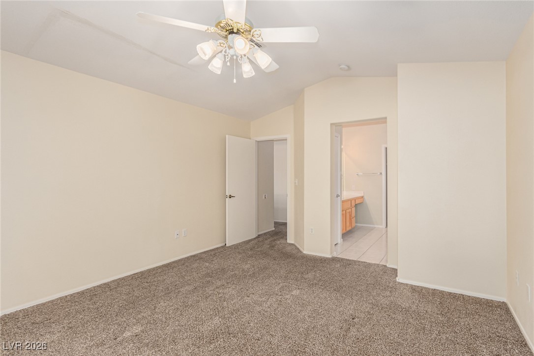 2148 Point Mallard Drive Henderson, NV 89012 - Photo 16 of 31 Unfurnished bedroom with lofted ceiling, light carpet, ensuite bath, and ceiling fan