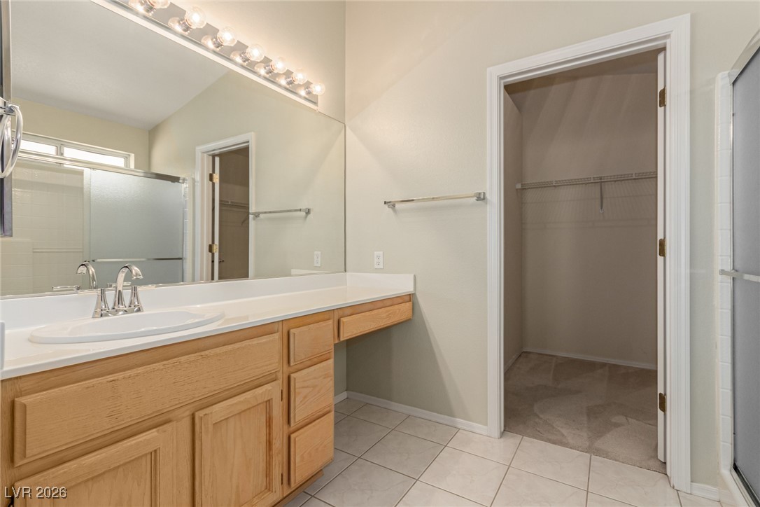 2148 Point Mallard Drive Henderson, NV 89012 - Photo 17 of 31 Full bathroom featuring a stall shower, a spacious closet, vanity, and light tile patterned flooring
