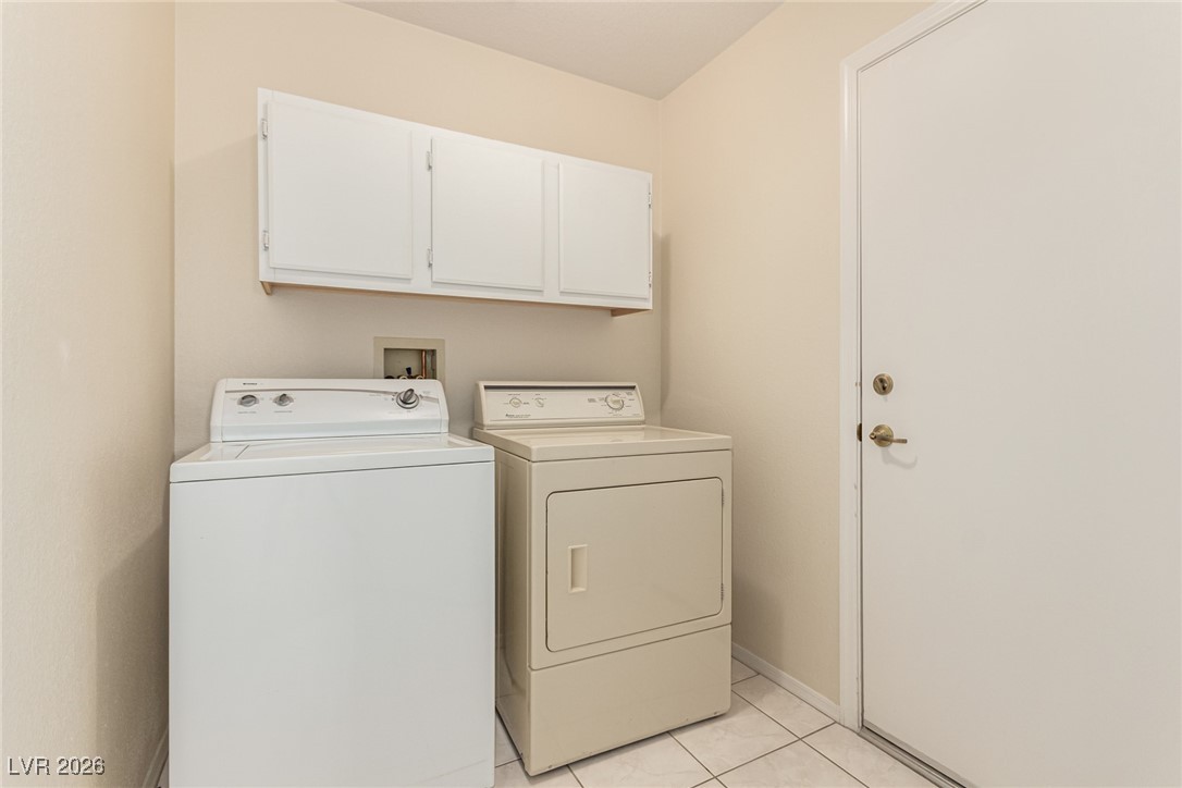 2148 Point Mallard Drive Henderson, NV 89012 - Photo 23 of 31 Laundry area with cabinet space, washing machine and dryer, and light tile patterned floors