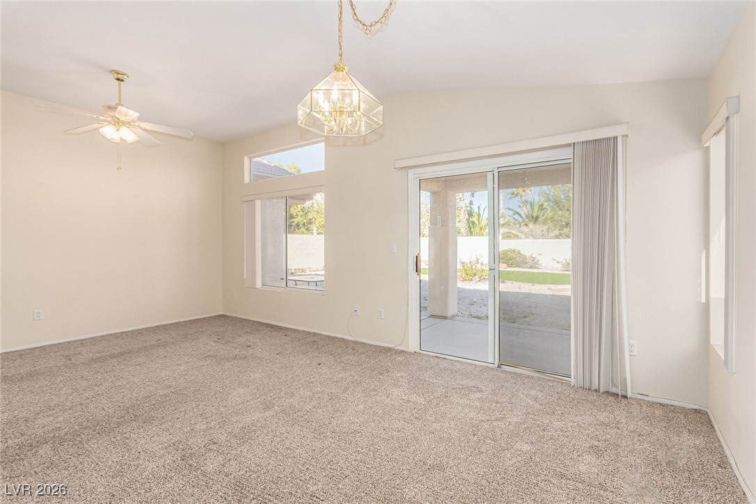 2148 Point Mallard Drive Henderson, NV 89012 - Photo 7 of 31 Carpeted empty room with a chandelier, ceiling fan, and vaulted ceiling