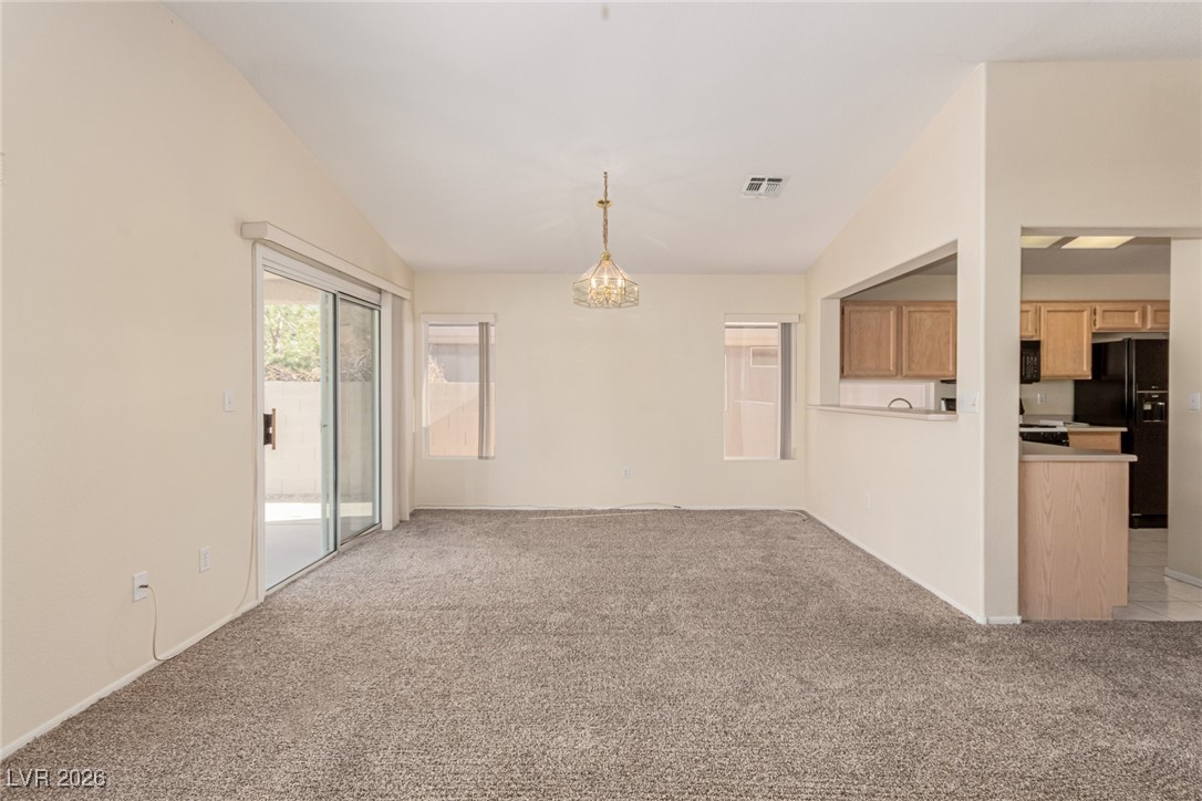 2148 Point Mallard Drive Henderson, NV 89012 - Photo 8 of 31 Spare room featuring light colored carpet, lofted ceiling, and a chandelier