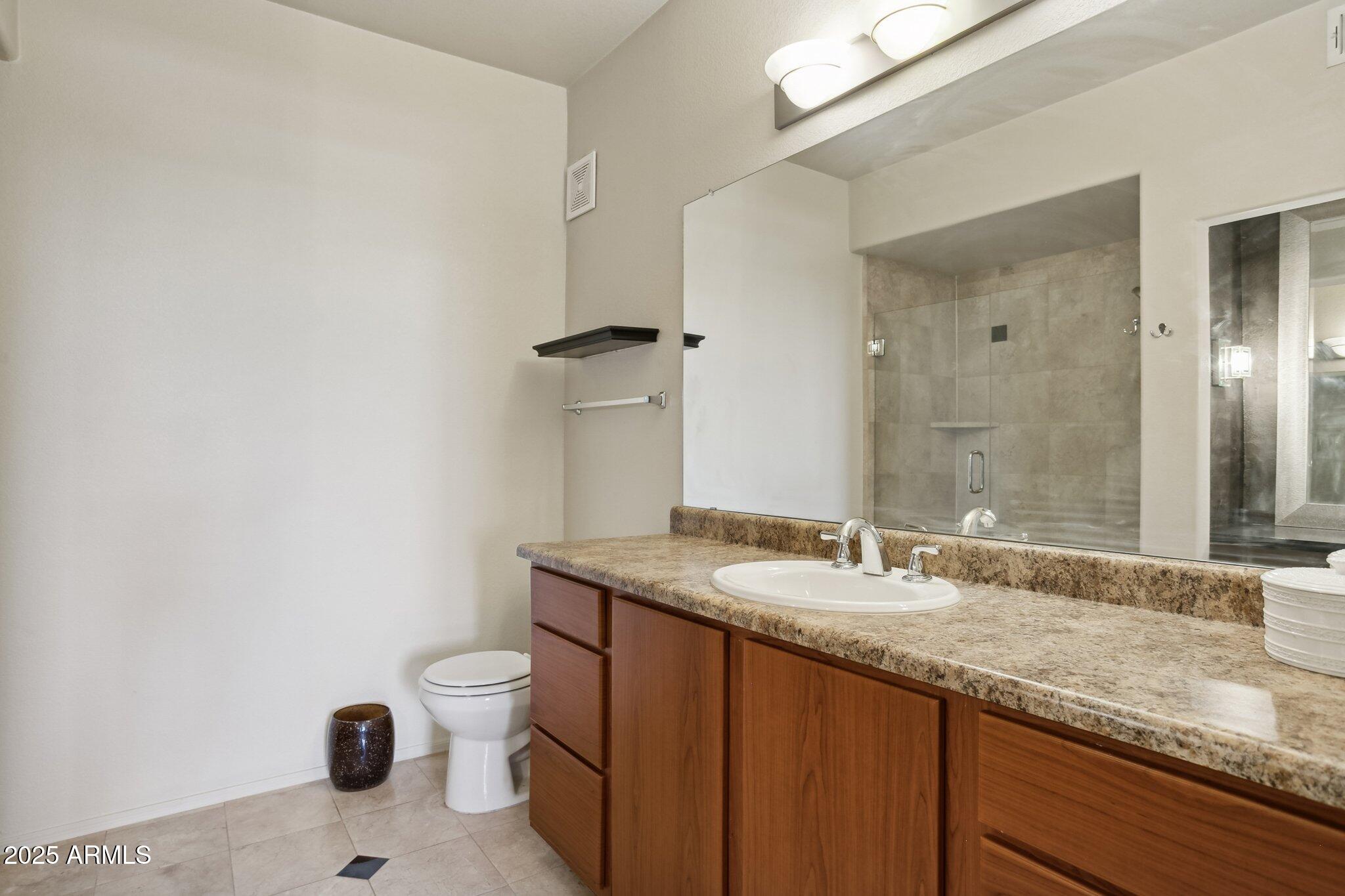 9820 North Central Avenue, Unit 317 Phoenix, AZ 85020 - Photo 11 of 26 a bathroom with a granite countertop sink a toilet and a mirror