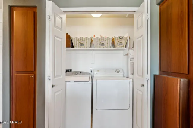 a view of washer and dryer with kitchen in the background