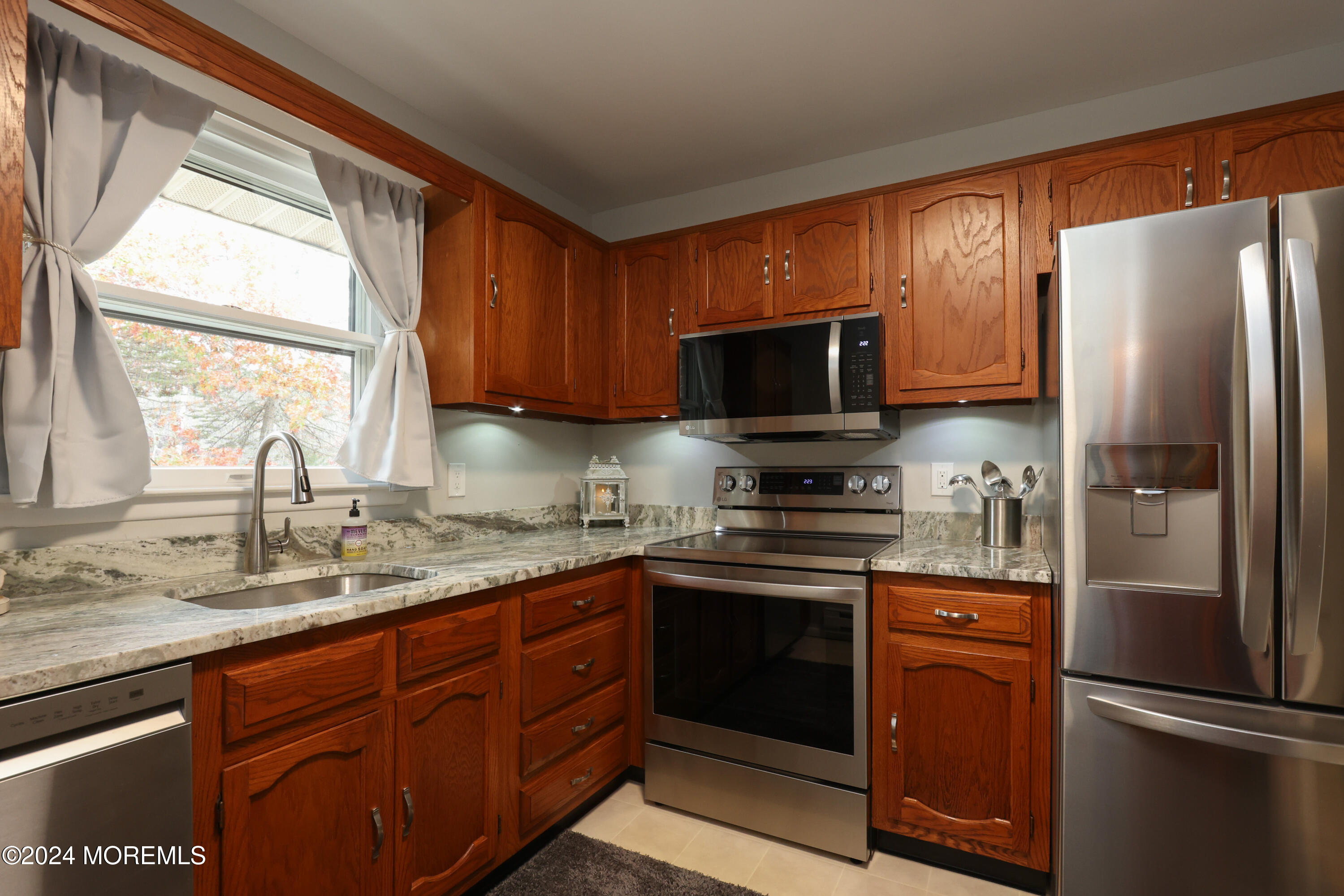 20 Cranberry Road, Unit 8 Manahawkin, NJ 08050 - Photo 22 of 42 a kitchen with stainless steel appliances granite countertop a refrigerator stove a sink dishwasher and microwave