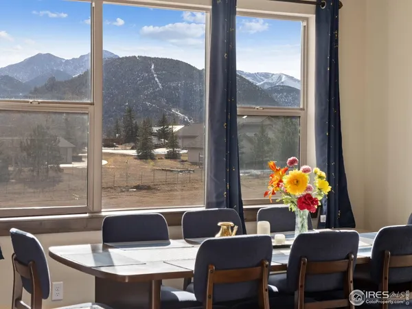 a dining room with furniture and a floor to ceiling window