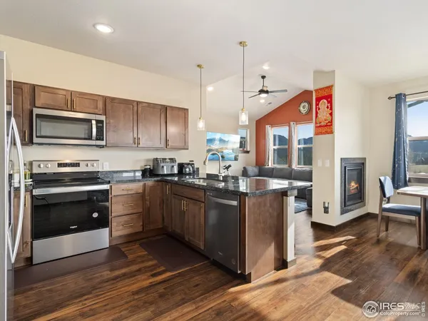 a kitchen with stainless steel appliances kitchen island granite countertop a stove a sink and a microwave