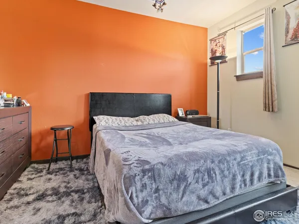 a bed sitting in a bedroom next to a bathroom with a sink