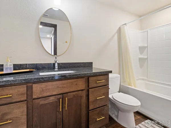 a bathroom with a granite countertop toilet sink and mirror