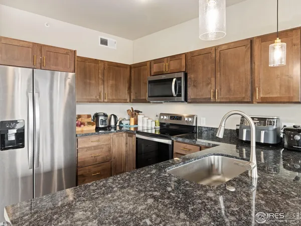 a kitchen with stainless steel appliances granite countertop a refrigerator sink and stove