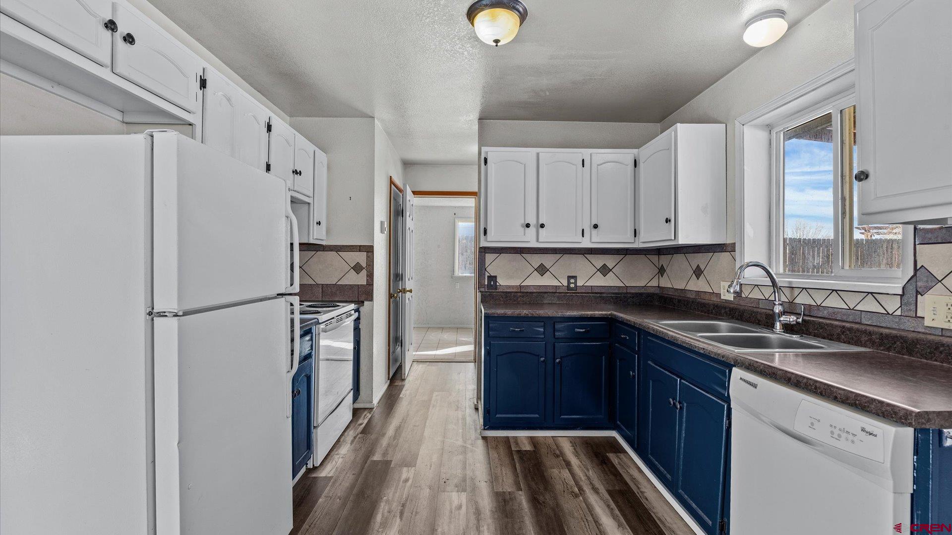 535 Labor Street Delta, CO 81416 - Photo 3 of 15 a kitchen with stainless steel appliances granite countertop a refrigerator a sink and white cabinets