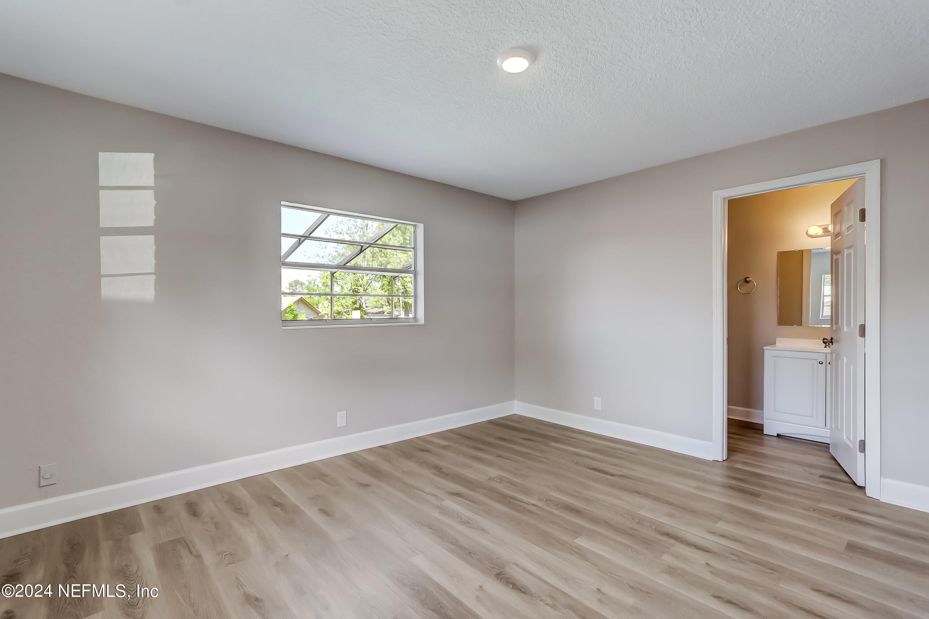 327 Neptune Road Orange Park, FL 32073 - Photo 13 of 40 an empty room with wooden floor and windows