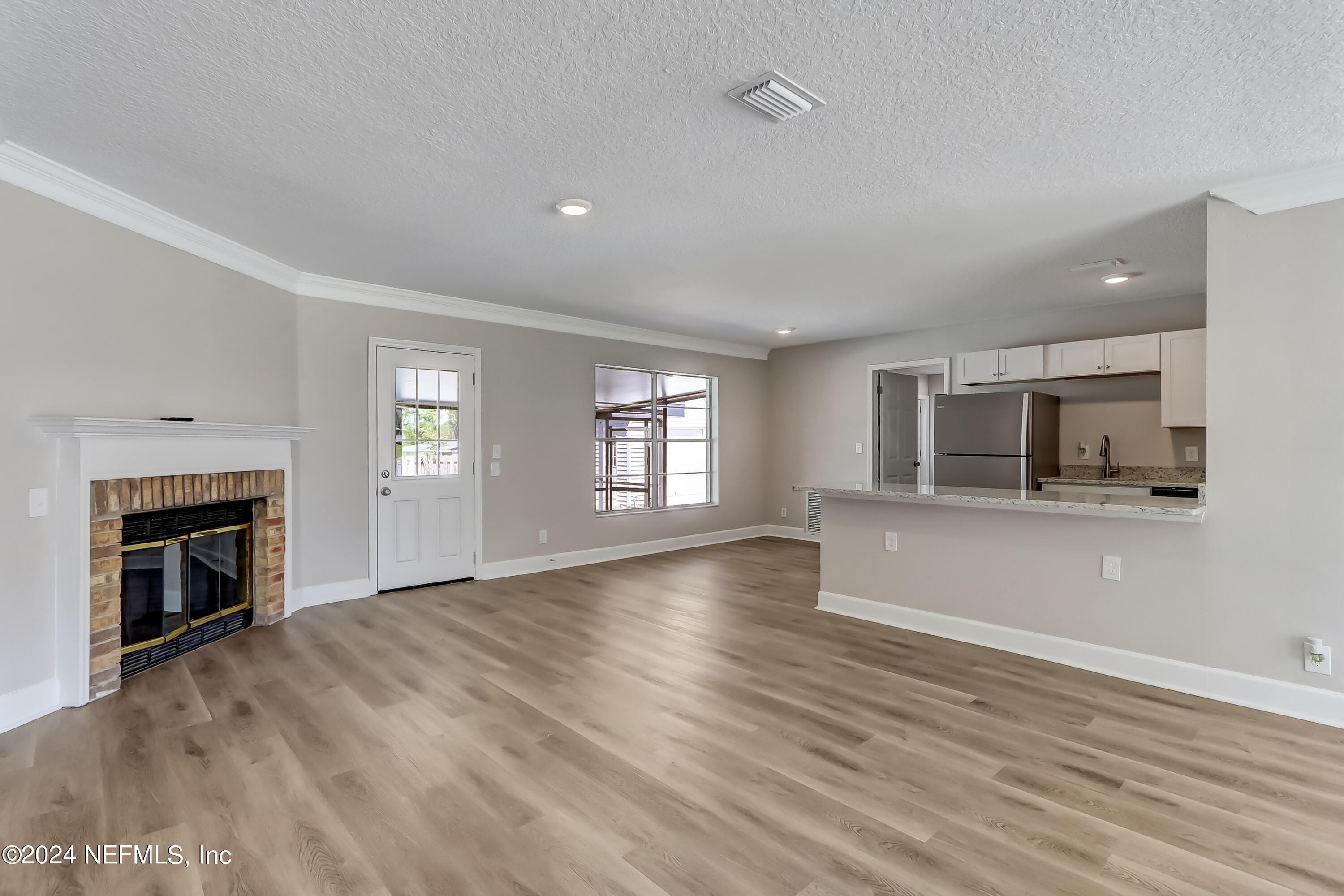 327 Neptune Road Orange Park, FL 32073 - Photo 16 of 40 a view of empty room with kitchen and fireplace