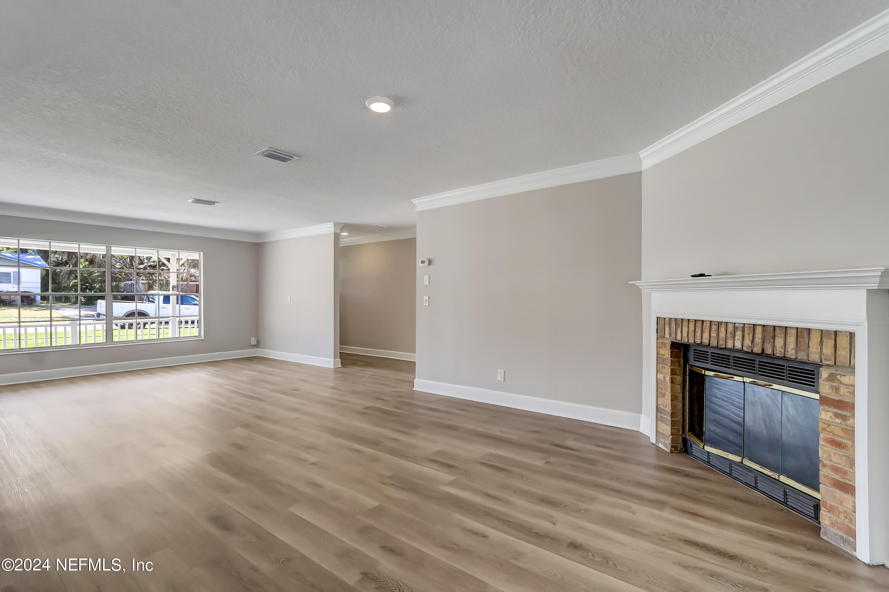 327 Neptune Road Orange Park, FL 32073 - Photo 19 of 40 a view of an empty room with a fireplace and a window