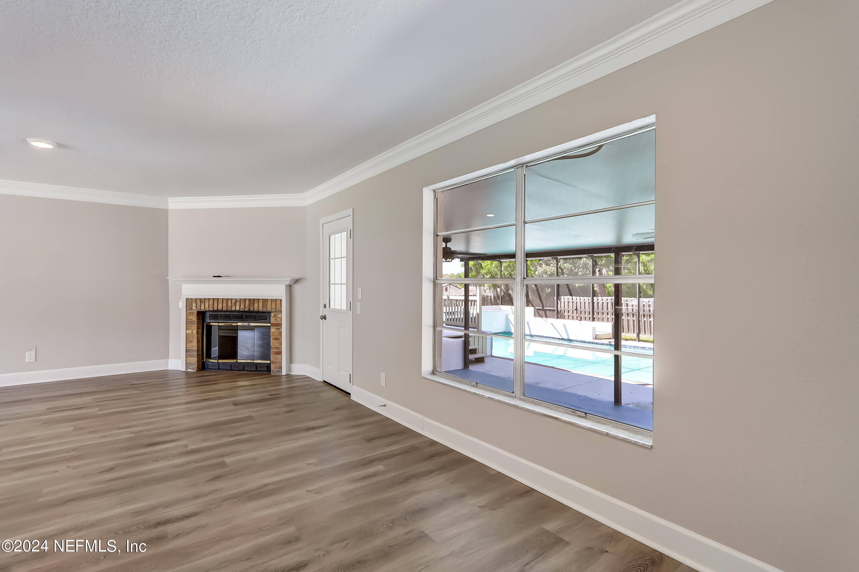 327 Neptune Road Orange Park, FL 32073 - Photo 22 of 40 a view of an empty room with wooden floor and a window