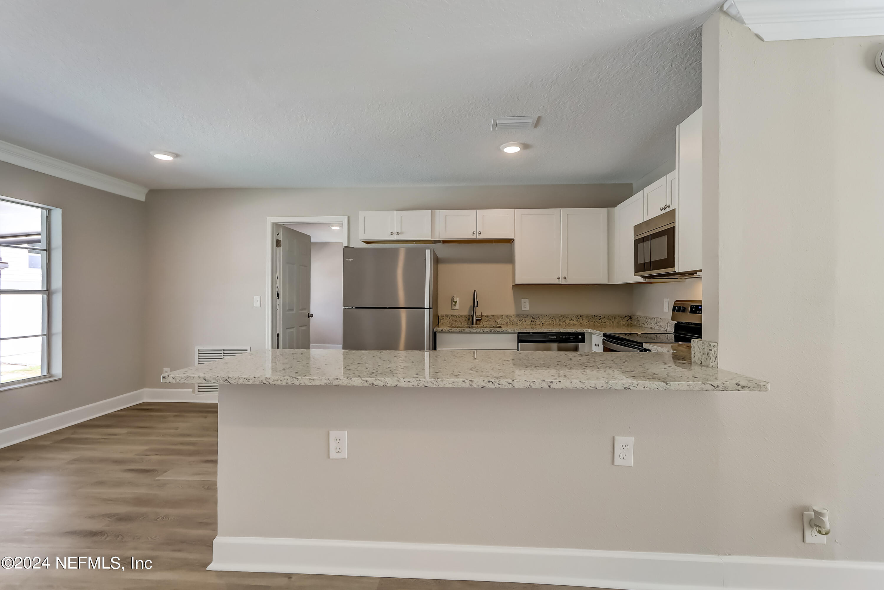 327 Neptune Road Orange Park, FL 32073 - Photo 25 of 40 a kitchen with stainless steel appliances granite countertop a sink refrigerator and microwave