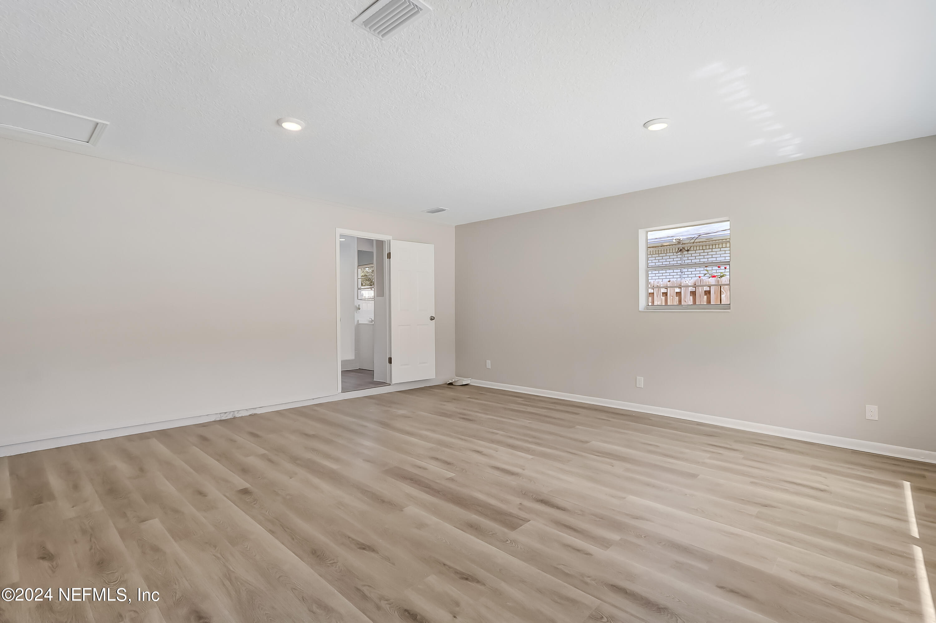 327 Neptune Road Orange Park, FL 32073 - Photo 32 of 40 a view of an empty room with wooden floor and a window