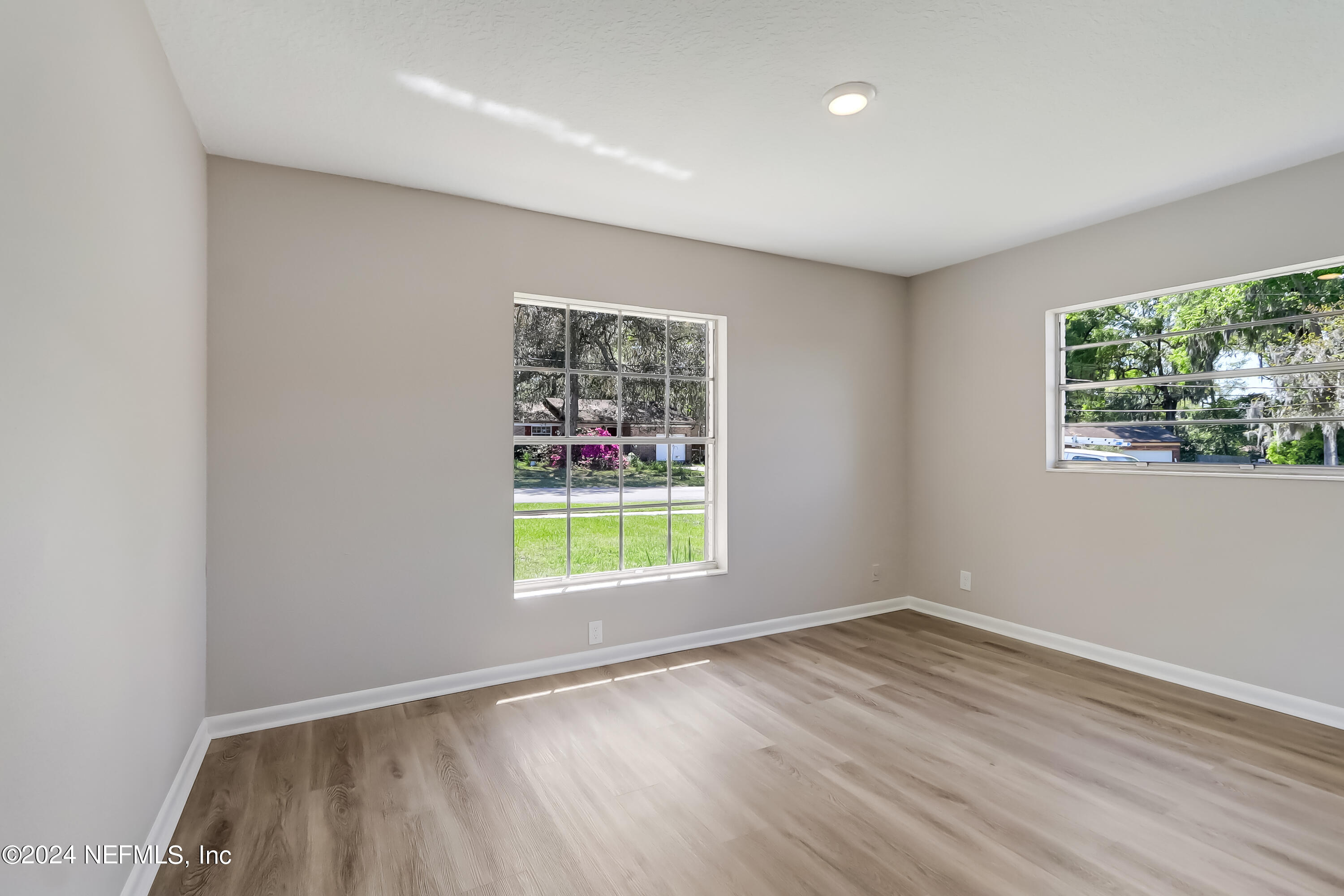 327 Neptune Road Orange Park, FL 32073 - Photo 7 of 40 an empty room with wooden floor and window