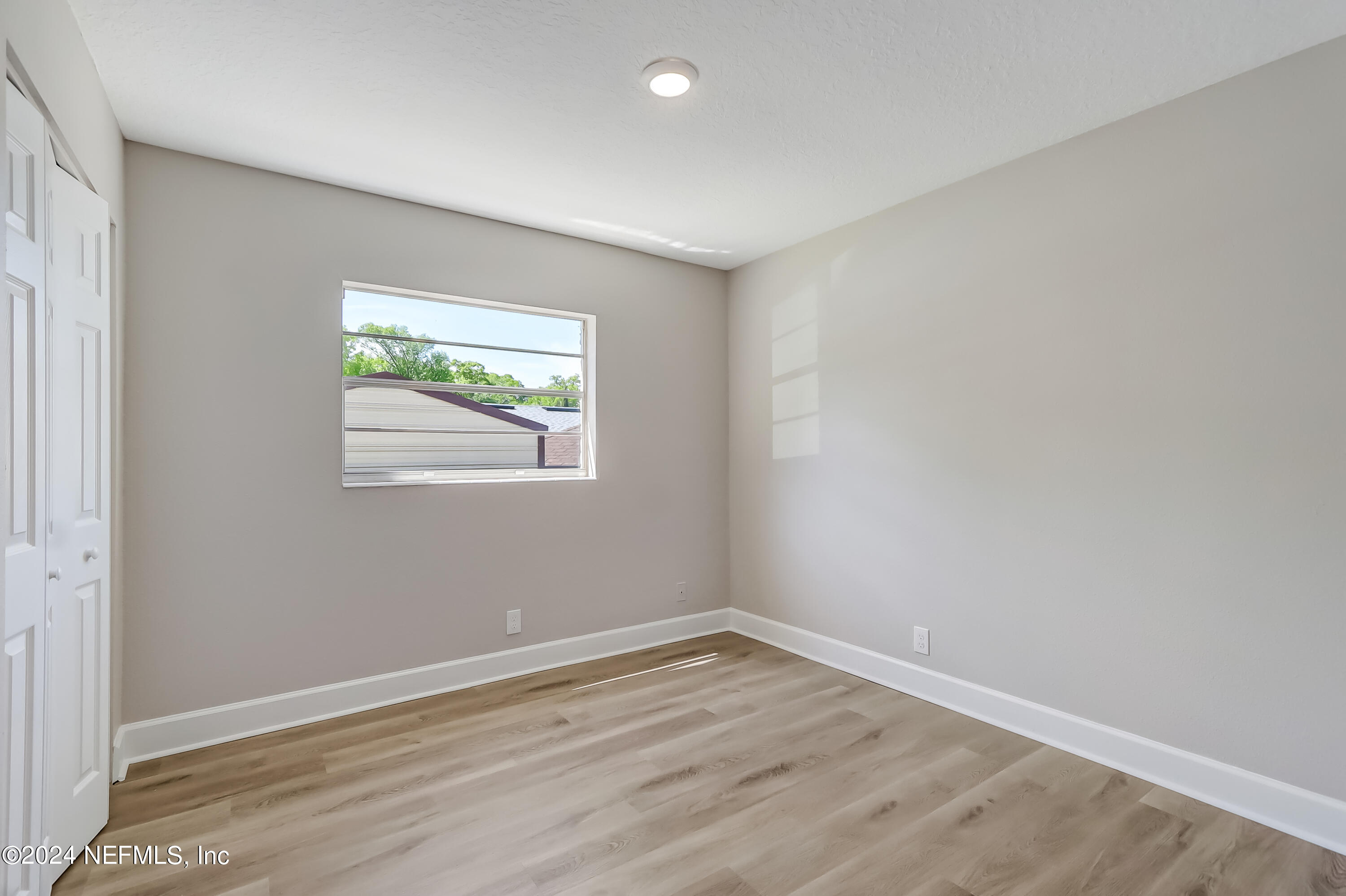 327 Neptune Road Orange Park, FL 32073 - Photo 9 of 40 wooden floor in an empty room with a window