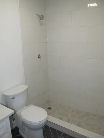 a white toilet sitting next to a shower