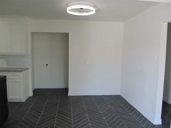 a view of a room with wooden floor and white walls